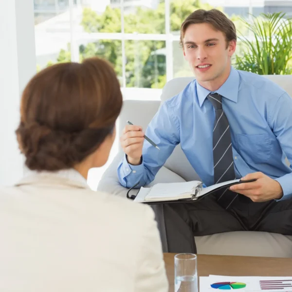 young businessman scheduling with colleague sitting couch